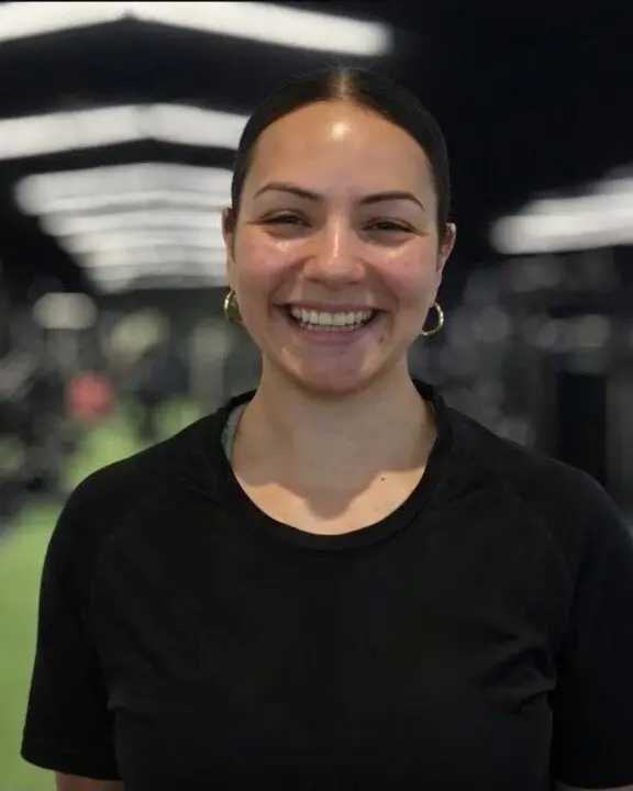 Jen St Martin smiling in a strength and conditioning space