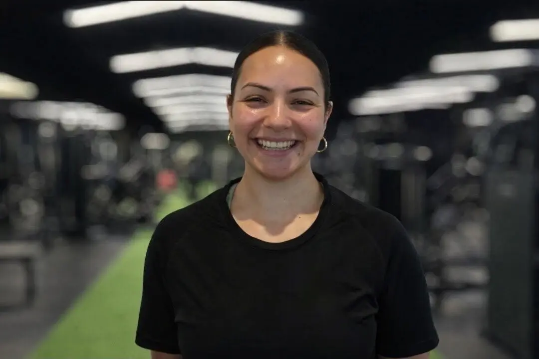 Jen smiling in a strength and conditioning environment