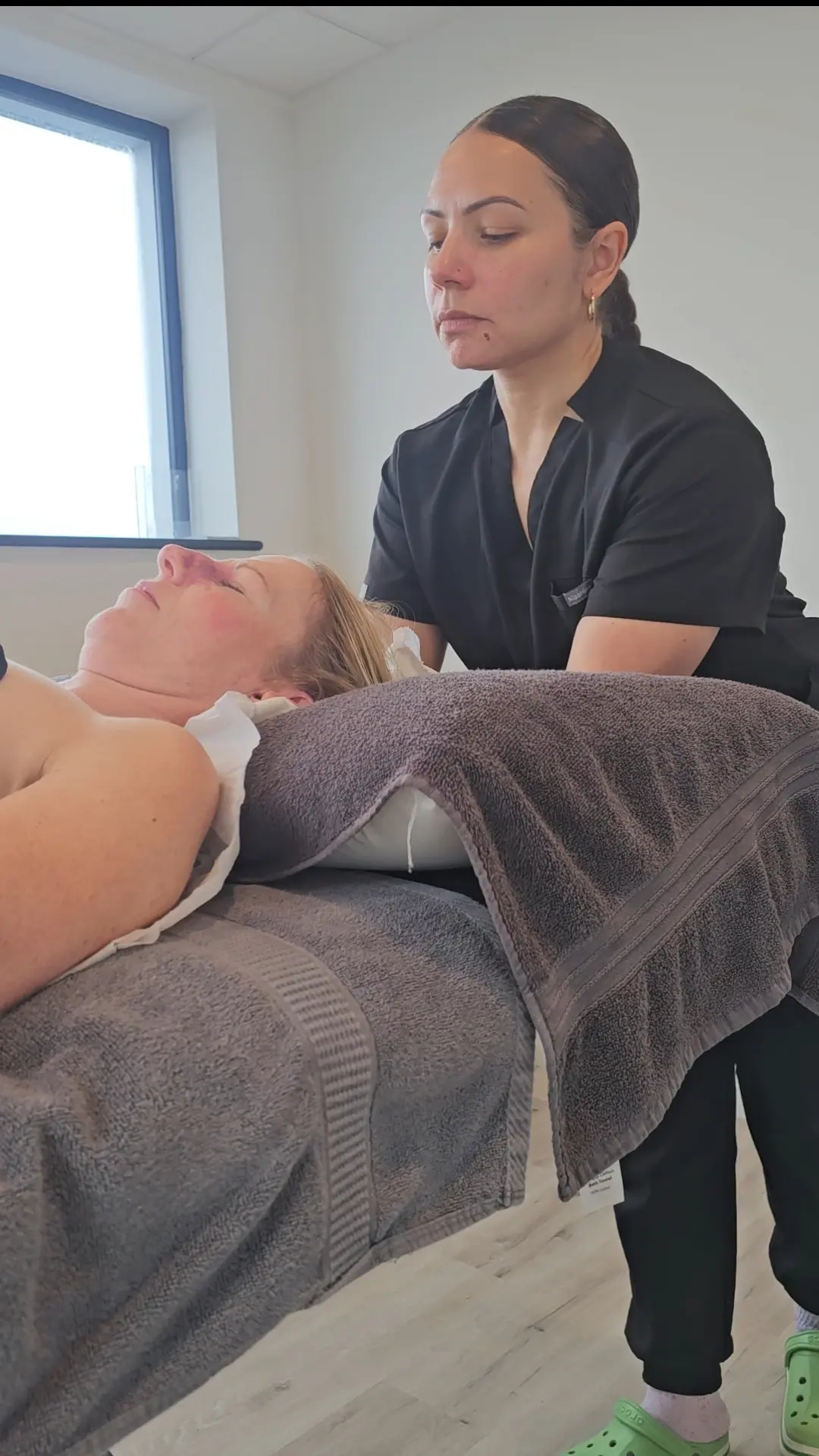 Jen providing hands-on osteopathic treatment in a bright clinic room